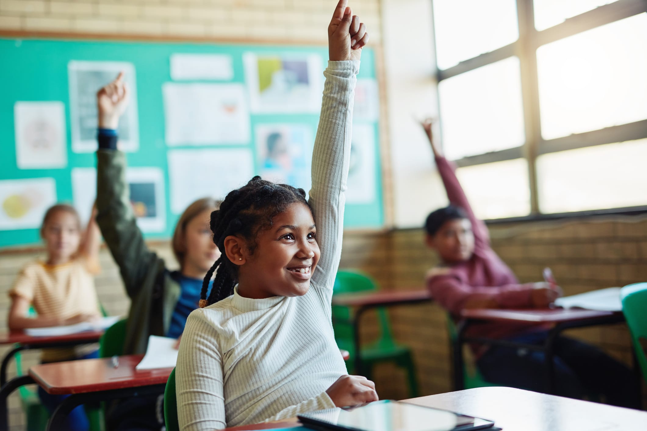 Young student raising hand in classroom setting