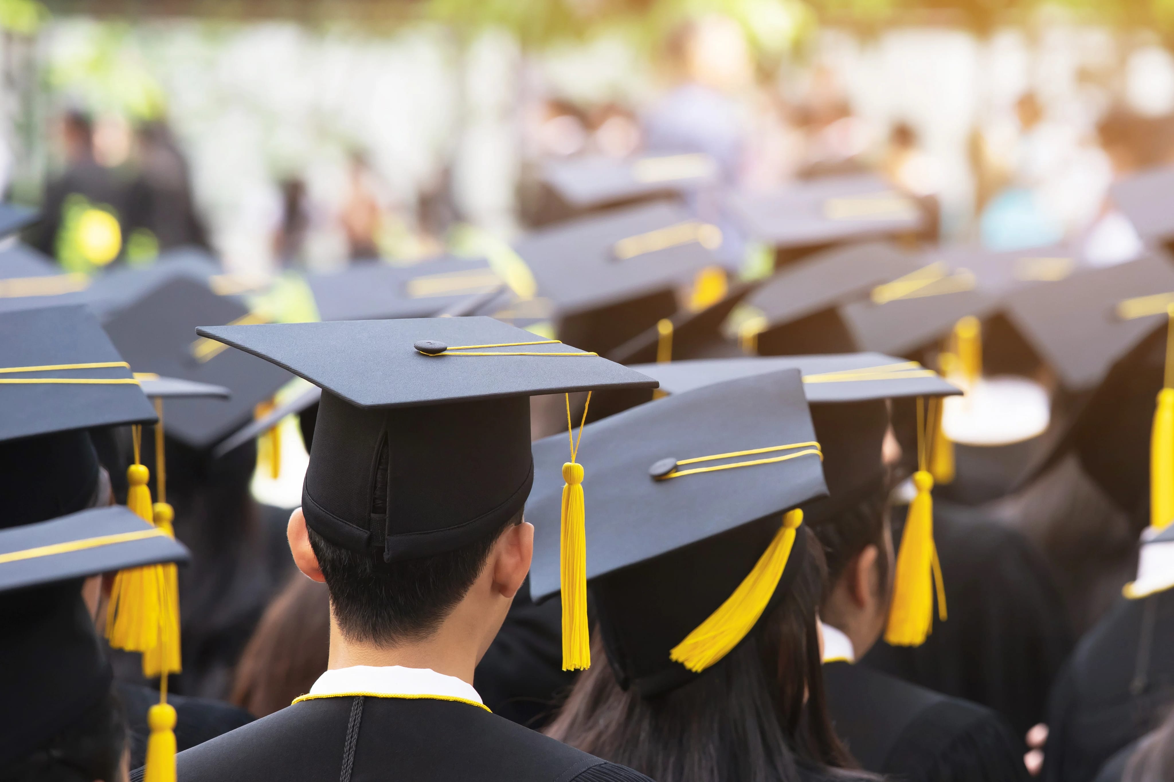 students sitting at graduation in traditional graduation caps