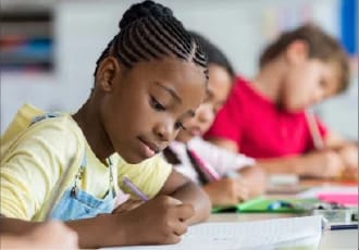 elementary school student writing at a desk