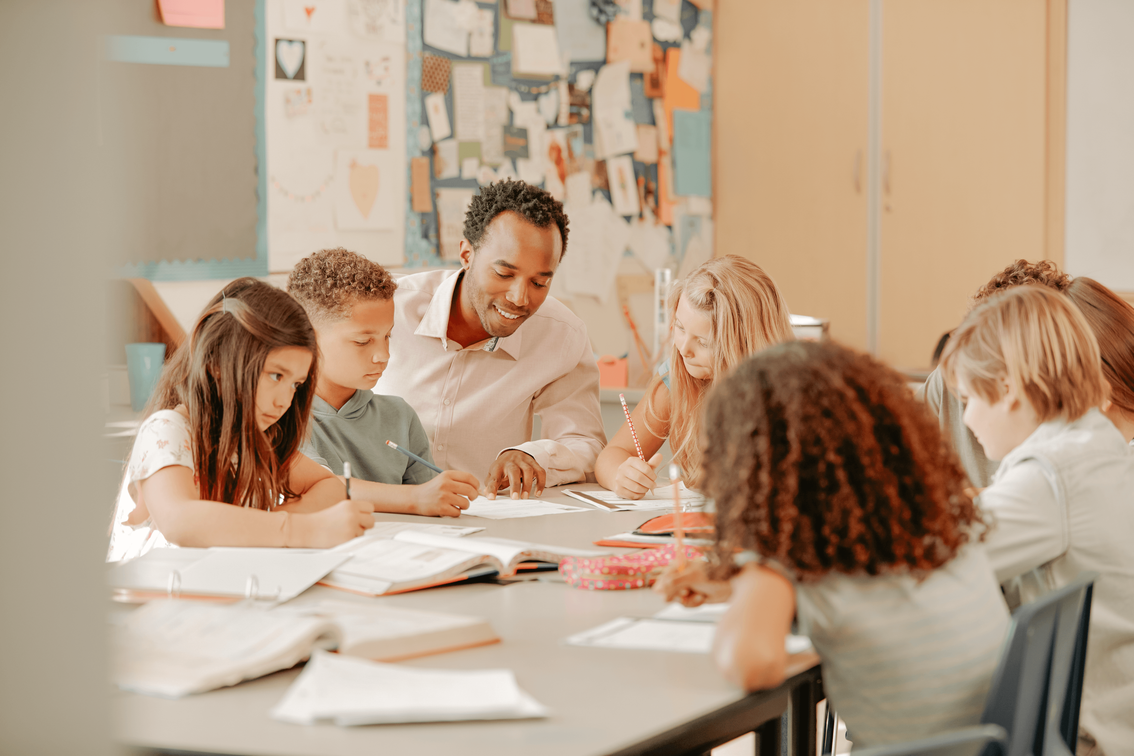 elementary students with teacher around classroom table