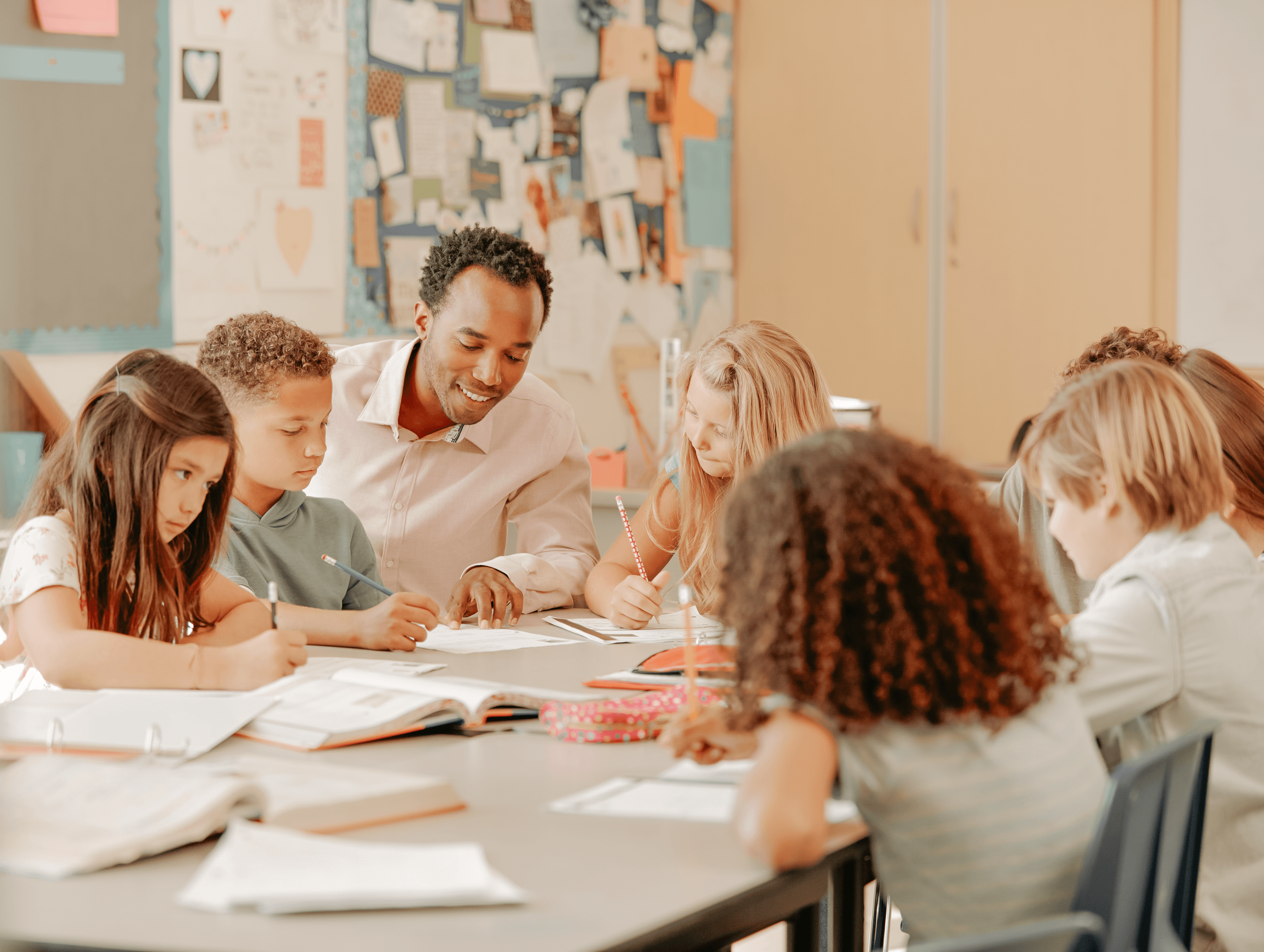 teacher sitting down in class reviewing ai prompting with two students